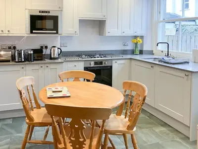 a kitchen with a wooden table and four chairs at 3 Catherine Cottages in Keswick