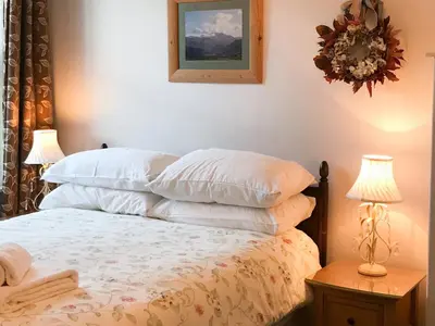 a bedroom with a bed with white pillows on it at 3 Catherine Cottages in Keswick