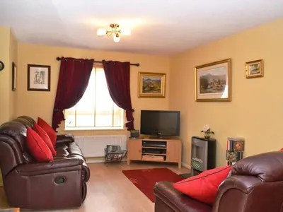 a living room with leather furniture and a television at Brundholme Glen in Keswick