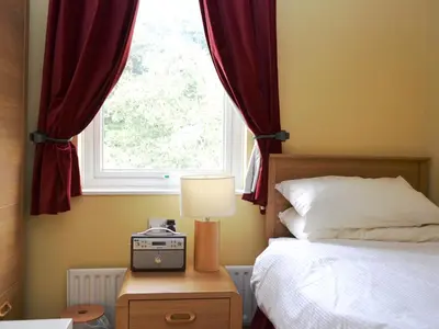 a bedroom with a bed and a window at Brundholme Glen in Keswick