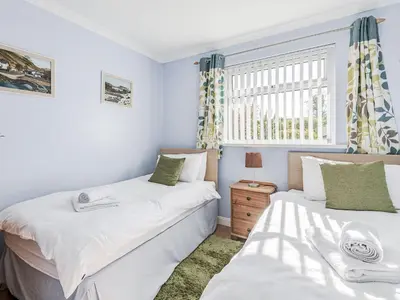 two beds in a small room with a window at Blencathra Bank in Keswick