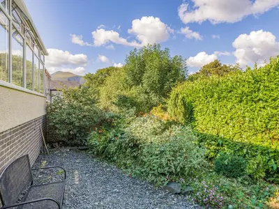 a bench sitting outside of a building next to a garden at Blencathra Bank in Keswick