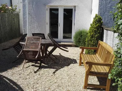 a patio with a table and chairs in front of a house at Carthwaite in Keswick