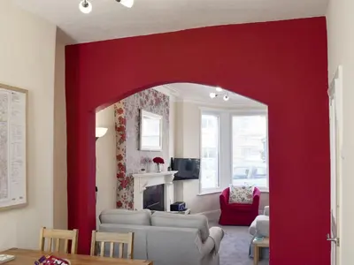 a living room with a red wall at Millie's Cottage in Keswick