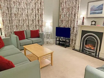 a living room with a fireplace and a tv at Kingstarn in Keswick