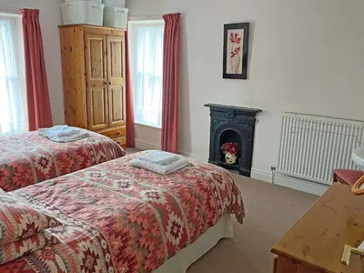 a bedroom with two beds and a fire place at Kingstarn in Keswick