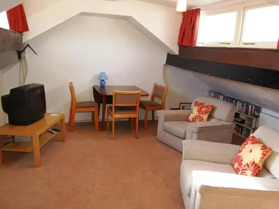 a living room with a couch and a tv and a table at Kingstarn in Keswick