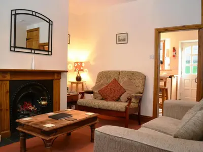 a living room with a fireplace and a chair at Alvamere in Keswick
