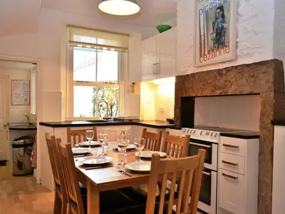 a kitchen with a table with wine glasses on it at The Ivy Cottage in Keswick