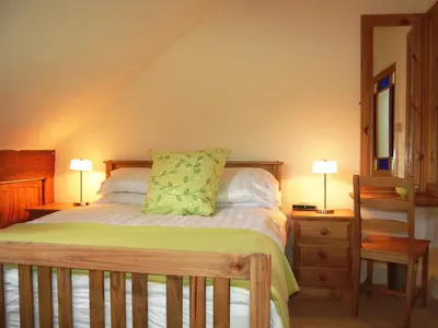 a bedroom with a bed with two lamps and a dresser at The Ivy Cottage in Keswick