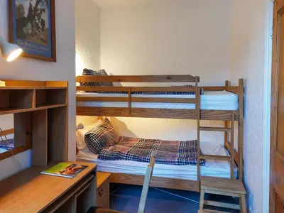 a room with three bunk beds and a desk at The Ivy Cottage in Keswick