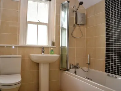 a bathroom with a toilet a sink and a bath tub at The Ivy Cottage in Keswick