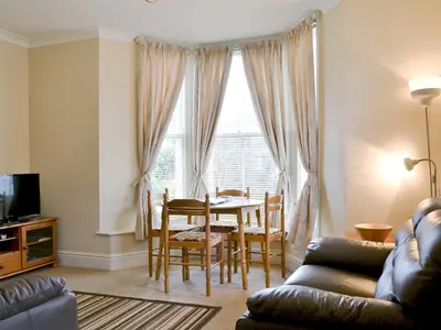 a living room with a table and a dining room at Helvellyn House Apartment in Keswick