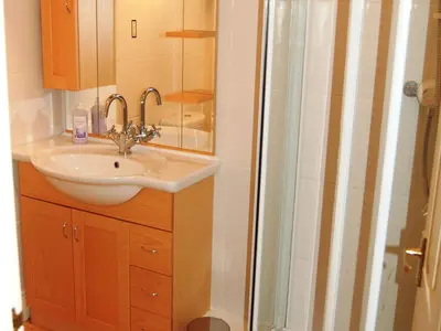 a bathroom with a sink and a shower at Helvellyn House Apartment in Keswick