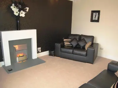 a living room with a couch and a fireplace at 3 The Hollies in Keswick