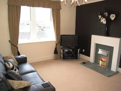 a living room with a couch and a fireplace at 3 The Hollies in Keswick