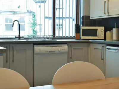 a kitchen with two chairs and a sink and a microwave at Wickhams View in Keswick