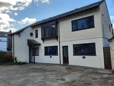a white house with black windows and a driveway at Wickhams View in Keswick