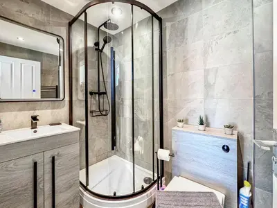 a bathroom with a shower and a toilet and a sink at High Style Apartment in Keswick