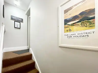 a painting on a wall next to a stairway at High Style Apartment in Keswick