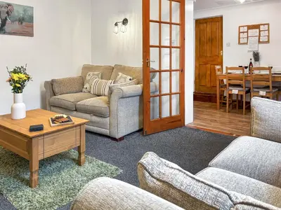 a living room with two couches and a table at Lavender Cottage in Keswick
