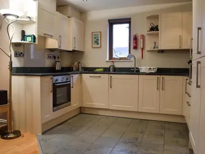 a kitchen with white cabinets and a sink at The Old Laundry 1 in Keswick
