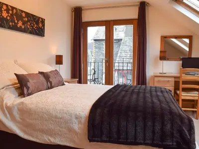 a bedroom with a bed and a desk and a window at The Old Laundry 1 in Keswick