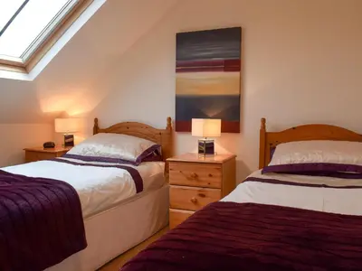 a bedroom with two beds and a painting on the wall at The Old Laundry 1 in Keswick