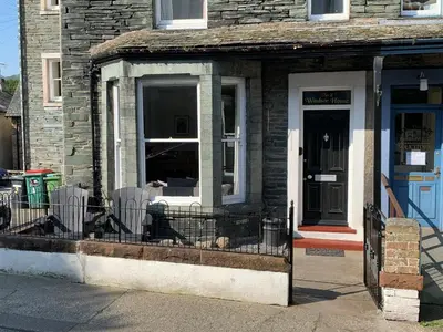 a building with a window with a dog in it at 2 Windsor House in Keswick