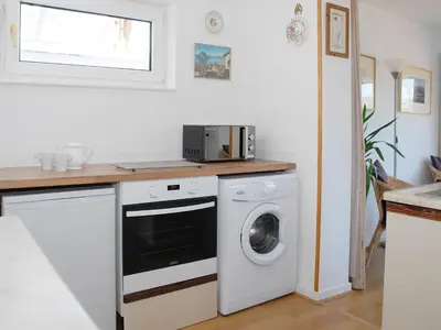 a kitchen with a washing machine and a microwave at Peel Wyke in Keswick