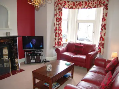 a living room with a couch and a tv at York House in Keswick