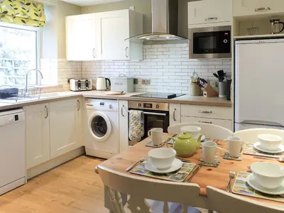 a kitchen with a wooden table with chairs and a sink at Hastings in Keswick