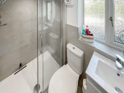 a bathroom with a toilet and a shower and a sink at The Croft in Keswick
