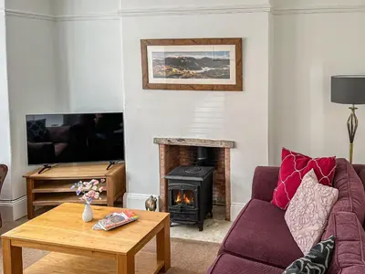 a living room with a couch and a fireplace at Green Ghyll in Keswick