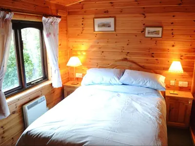 a bedroom with a bed in a log cabin at Glenmore Lodge in Keswick