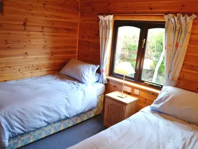 a bedroom with two beds in a log cabin at Glenmore Lodge in Keswick