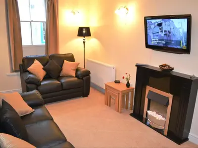 a living room with a couch and a fireplace at Uncle's Cottage in Keswick