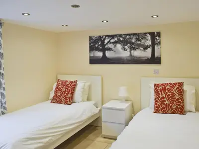 a bedroom with two beds and a painting on the wall at Falcon Crag in Keswick