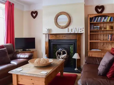 a living room with a coffee table and a fireplace at Valentine Cottage in Keswick
