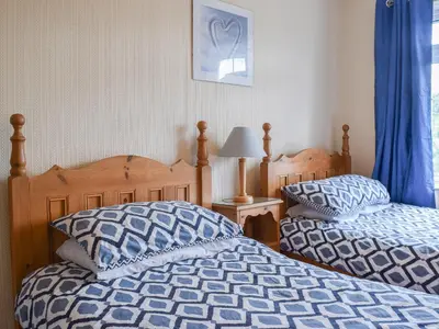 two beds sitting next to each other in a bedroom at Valentine Cottage in Keswick