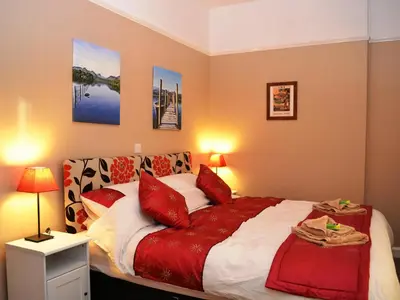 a bedroom with a large bed with red pillows at Riverbank in Keswick