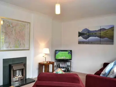 a living room with a couch and a tv at Haystacks in Keswick