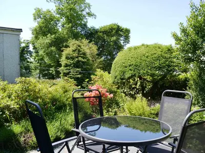a glass table and chairs on a patio at Haystacks in Keswick