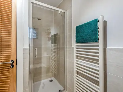 a shower with a glass door in a bathroom at Chaucer Lodge Apt 1 in Keswick