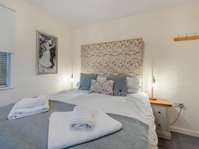 a bedroom with a large bed with towels on it at Chaucer Lodge Apt 1 in Keswick