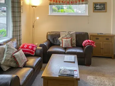 a living room with two leather couches and a coffee table at The Bolthole Formerly Candlemas in Keswick