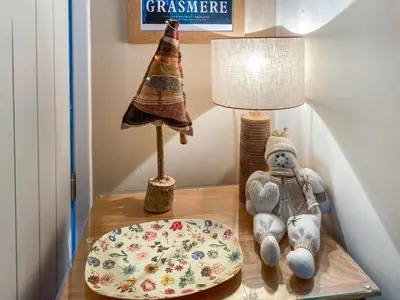 a stuffed teddy bear sitting on a table with a lamp at The Bolthole Formerly Candlemas in Keswick