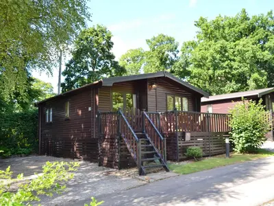 a log cabin with a staircase leading up to it at Fern Lodge- Burnside Park in Keswick