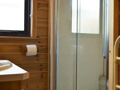 a bathroom with a shower and a toilet paper roll at Fern Lodge- Burnside Park in Keswick