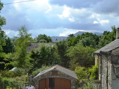 a barn with a wooden door in a yard at 5 The Plosh in Keswick
